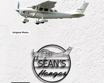 May include: Black metal sign with a circle design featuring a silhouette of a small airplane and the text "SEAN'S Hangar".