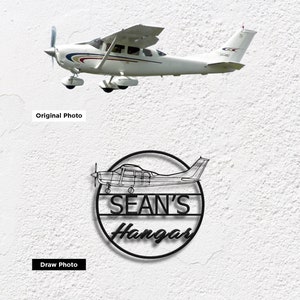 May include: Black metal sign with a circle design featuring a silhouette of a small airplane and the text "SEAN'S Hangar".