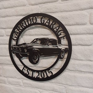 Puede incluir: Placa de metal negro con la silueta de un coche cl&aacute;sico y el texto "Garrido Garage Est. 2015".