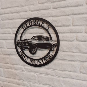 Puede incluir: Placa de metal negro con la silueta de un Ford Mustang de 1967 y el texto "GEORGE'S 1967 MUSTANG".