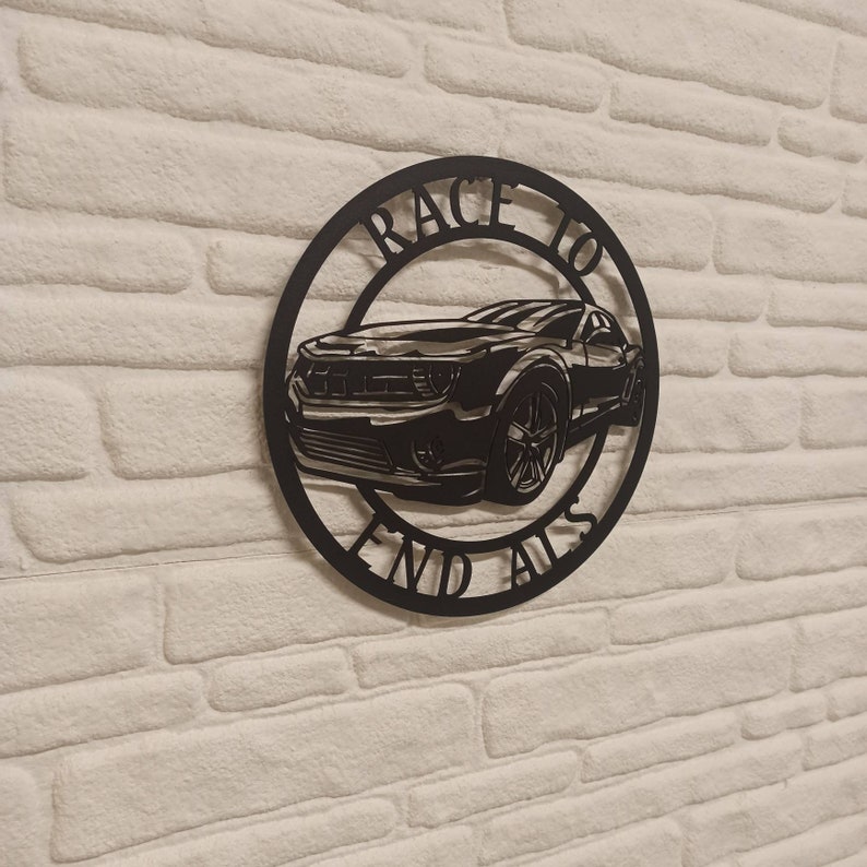 May include: Black metal wall art featuring a silhouette of a car with the text "Race to End Alls" around it.