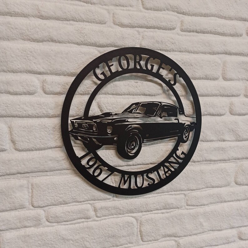 Puede incluir: Placa de metal negro con la silueta de un Ford Mustang de 1967 y el texto "George's 1967 Mustang".
