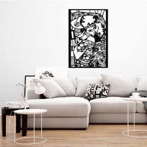 Op de afbeelding: Zwart-witte wandkunst die een knuffelend stel afbeeldt. De kunst is ingelijst in een zwart frame en hangt aan een witte muur boven een witte bank.