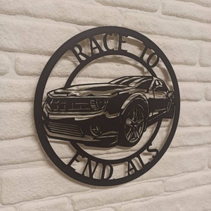 May include: Black metal wall art featuring a silhouette of a car with the text "Race to End Alls" around the edge.