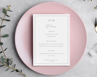 Może przedstawiać: Biała karta menu ślubnego z różowym tłem. Karta menu zawiera inicjały "H|M" i słowo "Menu" napisane kursywą. Menu zawiera przystawkę, danie główne i deser. Na dole karty znajdują się imiona "Harriet i Matthew" oraz data "17.12.2023".