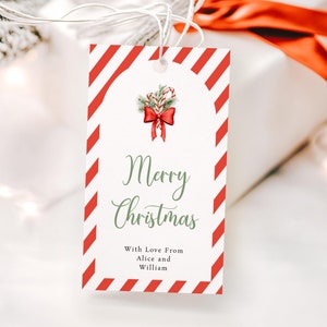 Puede incluir: Etiqueta de regalo a rayas rojas y blancas con una ilustración de bastón de caramelo verde y rojo y el texto "Feliz Navidad" con las palabras "Con amor de Alice y William" debajo.