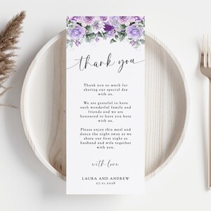 Peut inclure: Une carte de remerciement blanche avec des fleurs violettes en haut. Le texte dit "merci" dans une police d'écriture cursive. La carte comprend un message remerciant les invités d'avoir assisté au mariage et d'avoir partagé leur journée spéciale. La carte est signée "avec amour, Laura et Andrew" et comprend la date "27.11.2026".