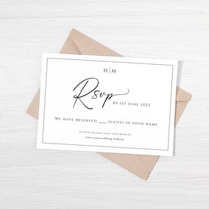 May include: A white RSVP card with black text. The text reads "HM RSVP by 1st June 2021 We have reserved ____ seat(s) in your name To RSVP please visit our website www.yourwedding website"