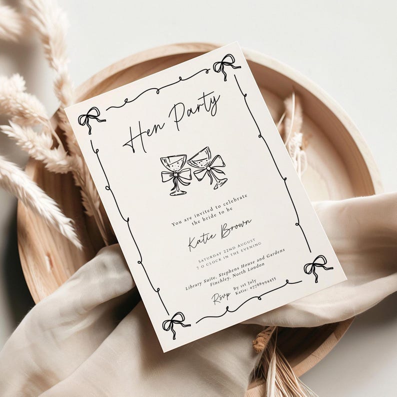 May include: A cream-colored invitation with black text and illustrations for a "Hen Party." The invitation features a decorative border with bows, two champagne glasses, and event details, including the bride's name and date.
