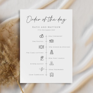 May include: A white wedding order of the day card with black text and icons. The card lists the events for the day, including the ceremony, photos, dinner, speeches, cake cutting, first dance, buffet, fireworks, and carriages. The date is December 17th, 2025.