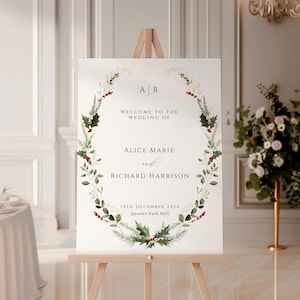 Könnte beinhalten: Ein weißes Hochzeitsschild mit einem grünen und roten Blumenkranz. Das Schild lautet "Willkommen zur Hochzeit von Alice Marie und Richard Harrison, 12. Dezember 2026, Queens Park Hall."