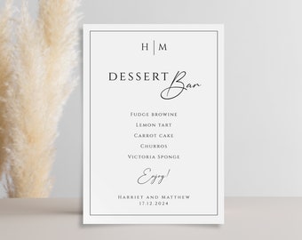 Może przedstawiać: Biały znak z czarnym tekstem, na którym widnieje napis "HM Dessert Bar" i lista deserów: Fudge Brownie, Lemon Tart, Carrot Cake, Churros i Victoria Sponge. Znak zawiera również tekst "Enjoy!" i "Harriet and Matthew 17.12.2024".