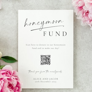 May include: A white card with black text that reads "honeymoon FUND".  The card has a QR code and the text "Scan here to donate to our honeymoon fund and to make our day!"  The card also has the text "thank you from the newlyweds ALICE AND JACOB 20th December 2025".