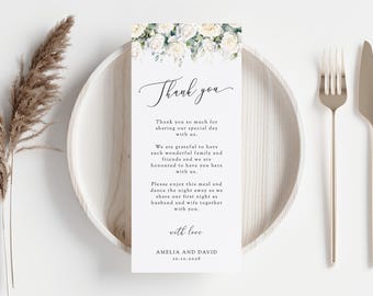 May include: A white wedding thank you card with a floral design at the top. The text reads "Thank you. Thank you so much for sharing our special day with us. We are grateful to have such wonderful family and friends and we are honored to have you here with us. Please enjoy this meal and dance the night away as we share our first night as husband and wife together with you. With love, Amelia and David, 10.10.2036."