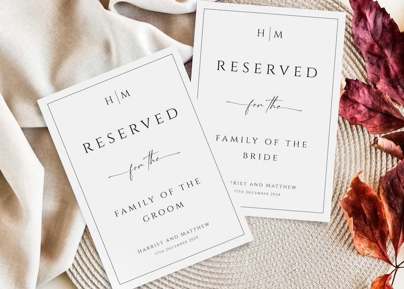 May include: Two white cards with black borders and text. The top card says "HM RESERVED for the FAMILY OF THE BRIDE" with the date "17TH DECEMBER 2024". The bottom card says "HM RESERVED for the FAMILY OF THE GROOM" with the date "17TH DECEMBER 2024".