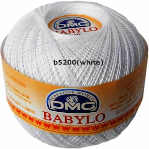 May include: A white ball of DMC Babylo crochet thread. The label reads "b5200 (white)" and includes the DMC logo and text in multiple languages. The thread is 100% cotton and 3-ply.