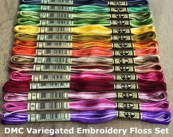 May include: A set of 20 DMC variegated embroidery floss spools. The spools are arranged in a rainbow pattern, with each spool featuring a different color combination. The spools are labeled with the DMC color number and a barcode.