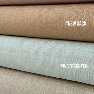 May include: Close-up of four fabric samples in various neutral colors. The top sample is a dusty rose, followed by tan, a light blue-green, and a beige color. Each sample has a textured weave. Text labels include #OLD SACK, #NEW SACK, #WATERGREEN, and #STONE.