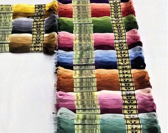 May include: A collection of embroidery floss spools in various colors, including red, blue, green, yellow, orange, purple, pink, and brown. Each spool is labeled with a number and the DMC brand name.