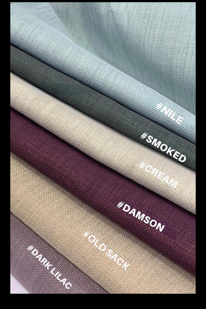 May include: Close-up of fabric swatches in various colors, including light blue, dark green, cream, and dark purple. The fabric has a textured appearance. The names of the colors are written on the fabric: #NILE, #SMOKED, #CREAM, #DAMSON, #OLD SACK, and #DARK LILAC.