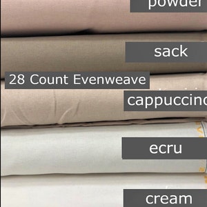 May include: A stack of fabric rolls in various neutral colors, including black, powder, sack, cappuccino, ecru, cream, and white. The text "28 Count Evenweave" is visible on one of the rolls. These fabrics are likely for crafting or sewing projects.