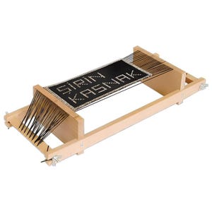 May include: A wooden weaving loom with black threads and a black woven section. The text "SIRIN KASNAK" is displayed on the woven section. The loom is rectangular with a light wood finish.