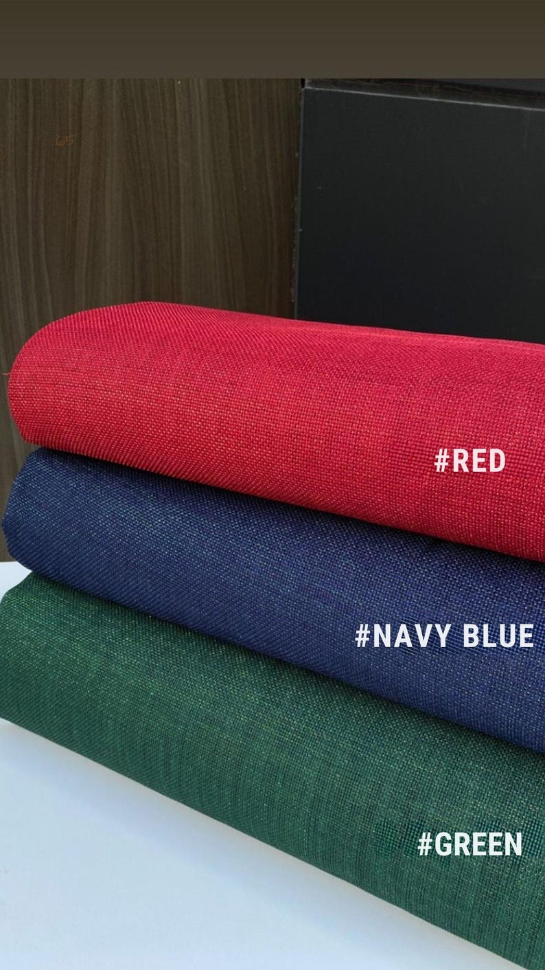 May include: Three fabric swatches in red, navy blue, and green. Each swatch has a textured appearance and is labeled with a hashtag and color name: #RED, #NAVY BLUE, and #GREEN. The fabrics are stacked, showcasing their different hues.