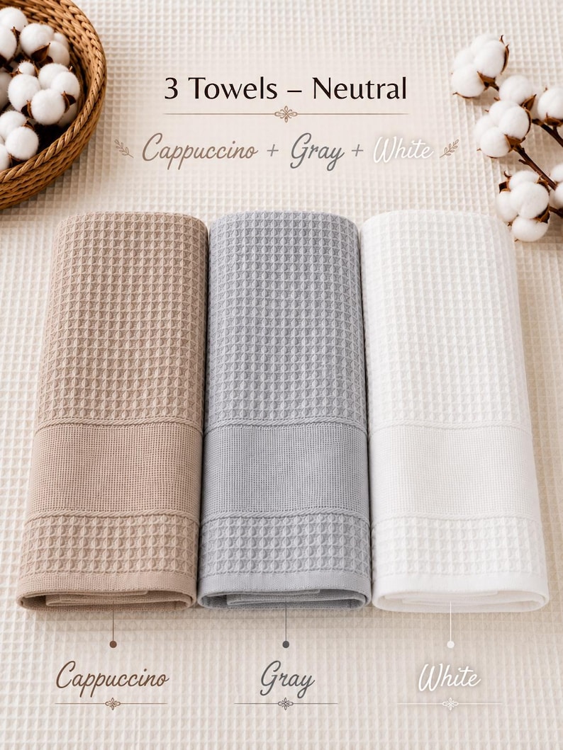 May include: A set of three waffle-weave towels in cappuccino, gray, and white. The text reads 3 Towels - Neutral, Cappuccino + Gray + White, with individual labels for Cappuccino, Gray, and White. Each towel features a textured grid pattern.
