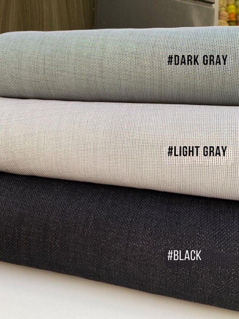 May include: Three rolls of fabric in varying shades of gray and black. The top roll is dark gray, the middle is light gray, and the bottom is black. Each roll has a textured appearance. Text on the rolls reads: #DARK GRAY, #LIGHT GRAY, and #BLACK.