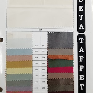 May include: A color chart of 100% silk taffeta fabric swatches in various colors, including white, light blue, peach, gold, beige, gray, lavender, pink, red, green, brown, and black. The chart is labeled "SETA TAFFETA" and includes numbers 501 through 521.