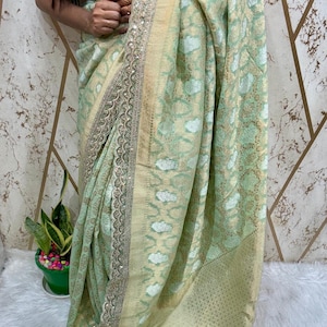 Elegant Neeta Ambani-inspired Pure Khaddi Georgette saree featuring intricate allover weaving. Adorned with a Sabyasachi-inspired