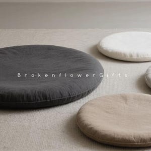 May include: Four round floor cushions in different colors and textures. The cushions are made of fabric and have a simple, minimalist design. The cushions are perfect for adding a touch of comfort and style to any room.