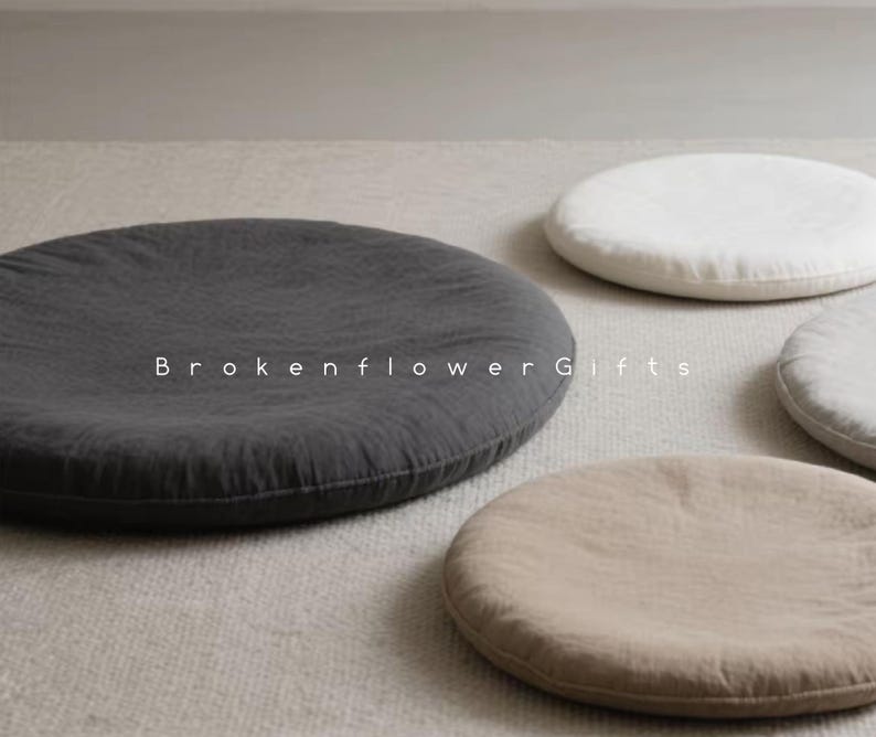 May include: Four round floor cushions in different colors and textures. The cushions are made of fabric and have a simple, minimalist design. The cushions are perfect for adding a touch of comfort and style to any room.