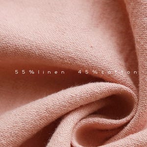 May include: Close-up of a soft, pink fabric with a textured weave. The fabric is labeled "55% linen 45% cotton".