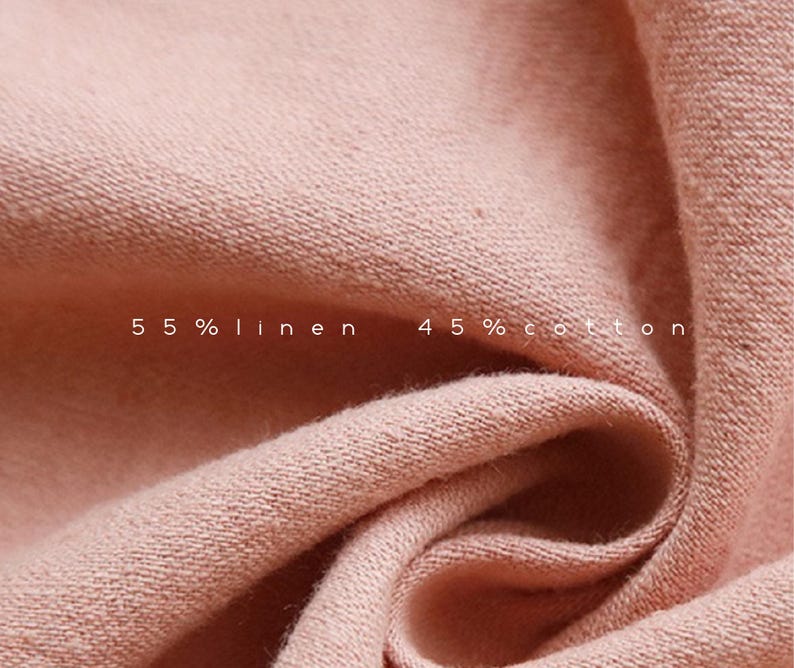 May include: Close-up of a soft, pink fabric with a textured weave. The fabric is labeled "55% linen 45% cotton".