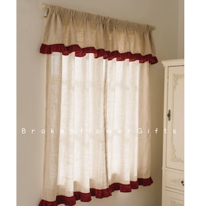 以下が含まれることがあります： ベージュのリネンのカーテン、赤いフリル付きのトリム。 カーテンはロッドに吊り下げられており、窓を部分的に覆っています。 「Brokenflower Gifts」の文字がカーテンの下部に印刷されています。