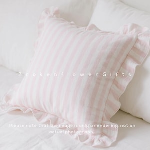 May include: A square, pink and white striped pillow with ruffled edges. The pillow is on a white bed with white sheets and pillows. The text "Brokenflower Gifts" is printed on the pillow. The text "Please note that the image is only a rendering, not an actual photograph" is also printed on the image.