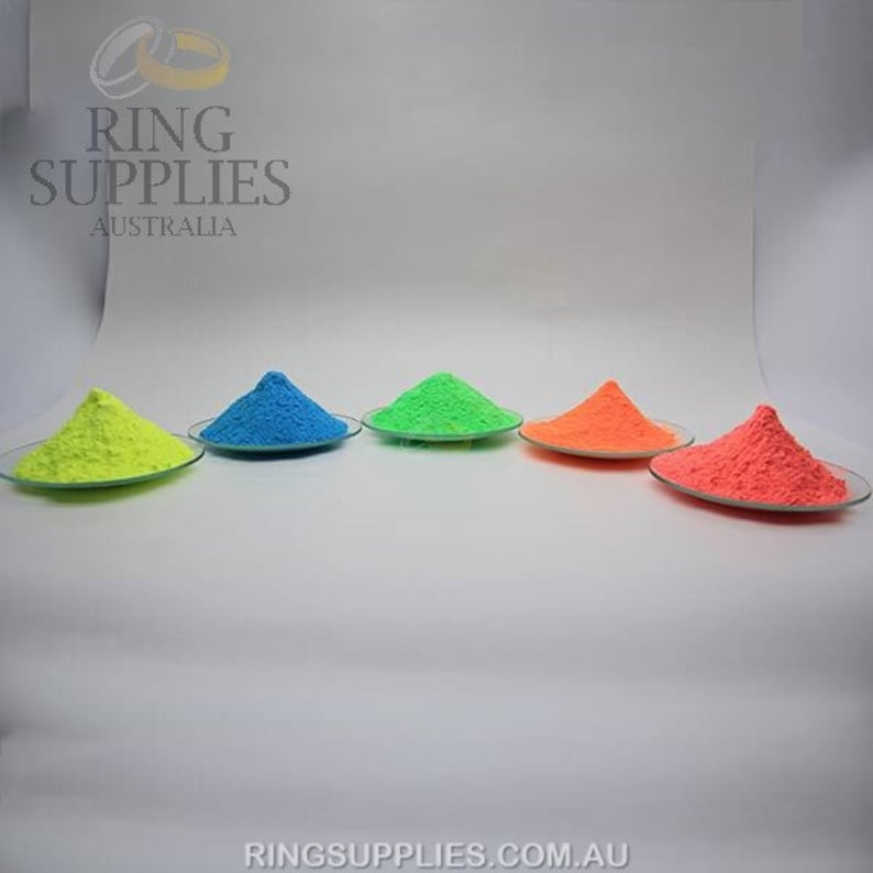 May include: Five small glass plates each hold a vibrant mound of colored powder: neon yellow, blue, green, orange, and red-orange. The image has the text "RING SUPPLIES AUSTRALIA" and "RINGSUPPLIES.COM.AU".