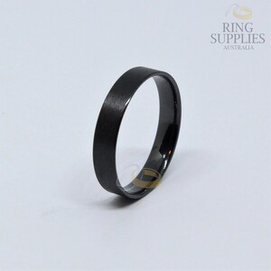 May include: A black brushed finish wedding band with a polished edge.