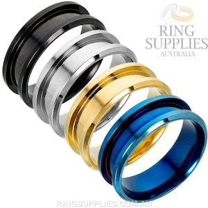 May include: Four different colored metal rings stacked on top of each other. The rings are black, silver, gold, and blue.