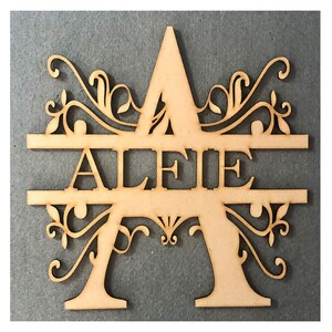 May include: A wooden cutout of the letter A with decorative flourishes. The name "ALERIE" is cut out of the center of the letter.
