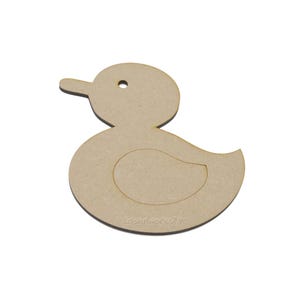 May include: A wooden duck-shaped cutout with a smooth, light brown surface. The duck has a round head, a small beak, and a circular body with an inner cutout. The text "LaserWorksluk" is printed at the bottom.