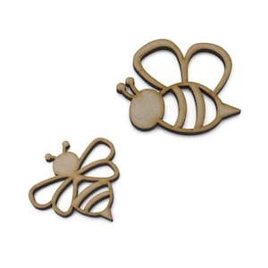 May include: Two wooden bee cutouts, one larger than the other. Both bees have black and white striped bodies and wings.