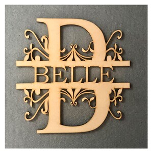 May include: Wooden cutout of the letter D with a decorative flourish design. The name "BELLE" is cut out of the center of the letter.