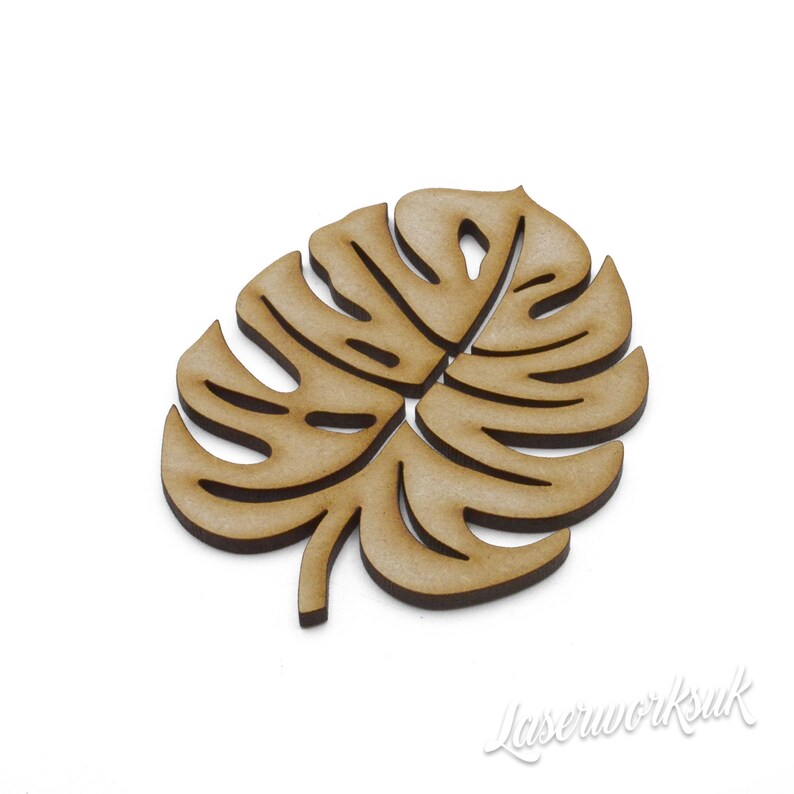 May include: A brown wooden cutout of a monstera leaf. The leaf is detailed with cutouts that resemble the veins of a real leaf.