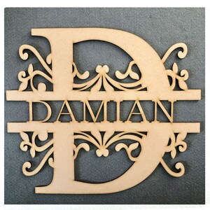 May include: A wooden sign with the name "DAMIAN" cut out in the center of a large letter "D". The letter "D" has a decorative design around it.