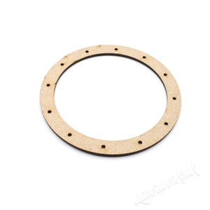 May include: A wooden circle with holes around the edge. The circle is light brown and has a smooth surface.