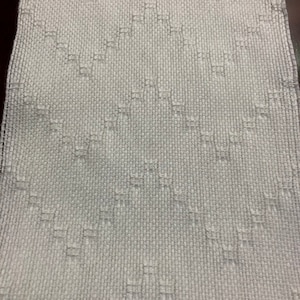 May include: White woven fabric with a diamond pattern.