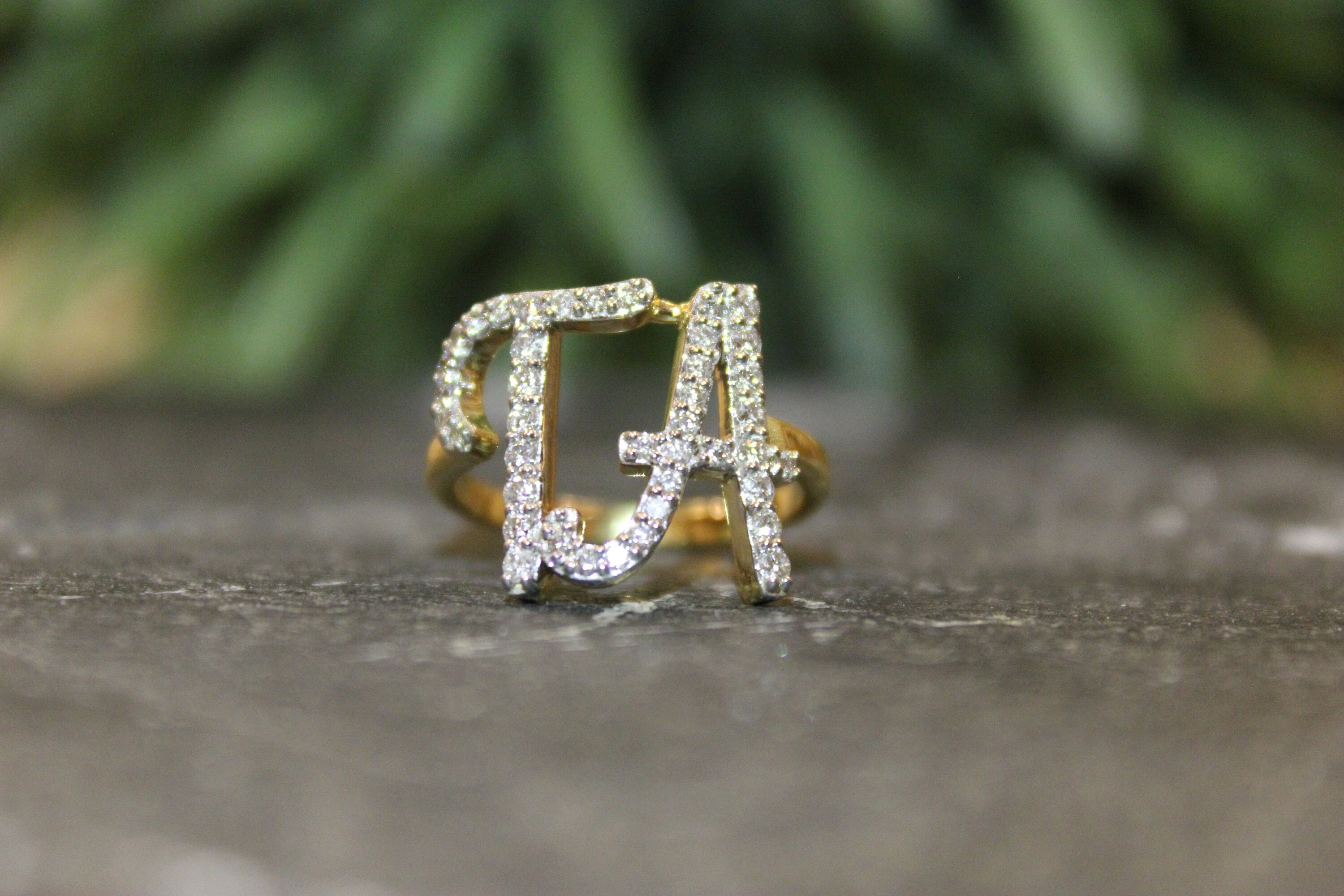 The letter D, in the alphabet set Diamond Ring, is gold and sits on a  faceted diamond set in a 14 karat gold ring Stock Photo - Alamy