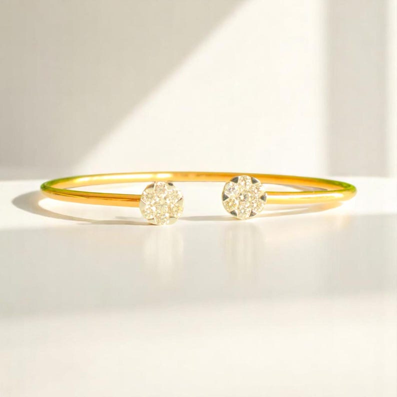 Pu&ograve; includere: Un braccialetto rigido in oro con due accenti rotondi di diamanti.